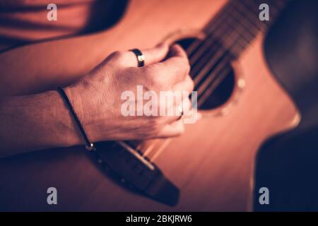 Primo piano di Male Musician che gioca su chitarra acustica marrone. Foto Stock