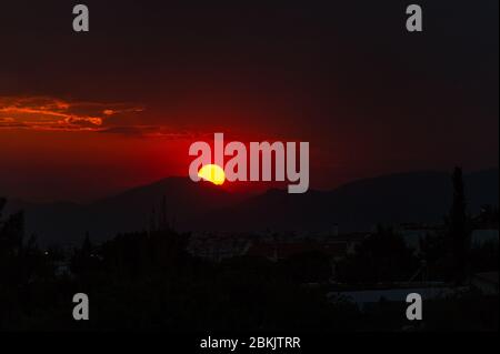 Un vivace tramonto rosso ad Atene, Grecia Foto Stock