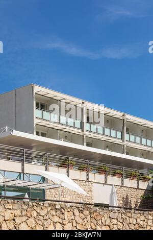 Bol, Croazia, 10 settembre 2019. Una facciata di un hotel con esterni bianchi e rocce in una giornata di sole in estate con un cielo blu. Architettura moderna, Michigan Foto Stock