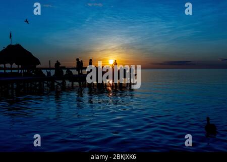 persone su un molo al tramonto Foto Stock