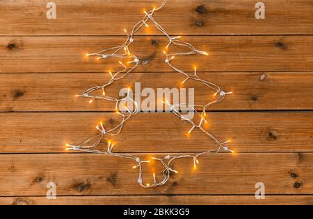 le luci di garland si illuminano a forma di albero di natale Foto Stock