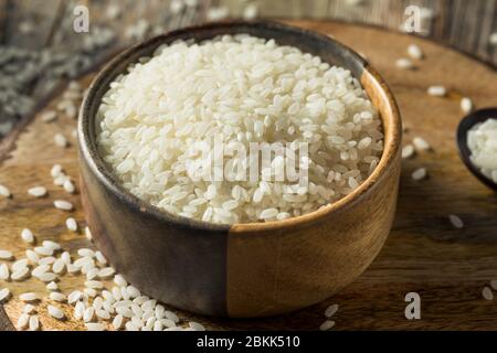 Riso bianco secco organico crudo in una ciotola Foto Stock