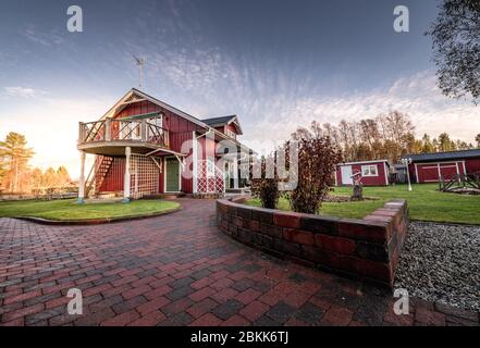 Bella villa in legno scandinava tradizionale in campagna, sera dopo la pioggia, patio in pietra bagnata, tradizionale stile casa rossa, Svezia, Norvegia Foto Stock