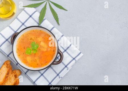 Zuppa di cannabis infusa in una ciotola su sfondo neutro chiaro con spazio per le copie Foto Stock