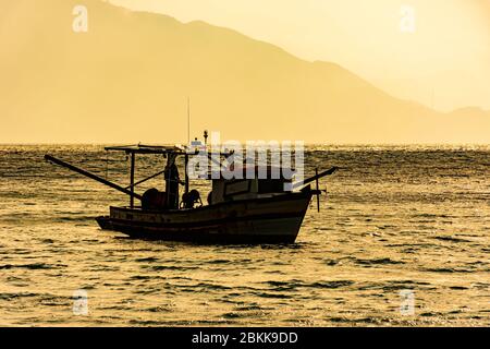 La sciabola di legno usata per la pesca che galleggia sul mare al tramonto a Ilhabela sulla costa di San Paolo, Brasile Foto Stock