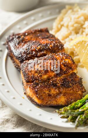 Pesce bianco mahimahi nero fatto in casa con asparagi e riso Foto Stock