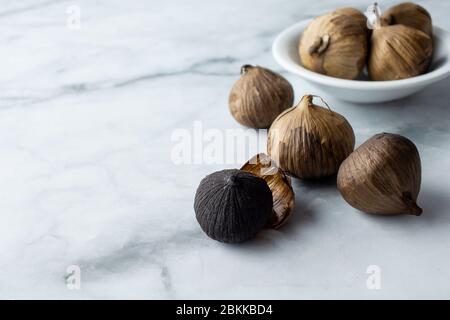 Un gruppo di aglio nero, bulbo d'aglio solo. Un ingrediente alimentare, o comunemente usato per la theraphy olistica dell'alimento. Foto Stock