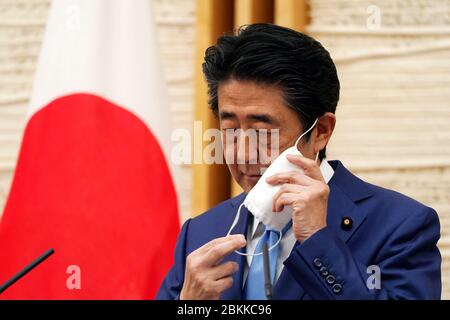 Tokyo, Giappone. 4 maggio 2020. Il primo ministro giapponese Shinzo Abe rimuove una maschera facciale per contribuire a frenare la diffusione del coronavirus prima di parlare in una conferenza stampa in cui ha annunciato un'estensione dello stato di emergenza della nazione presso l'Ufficio del primo ministro lunedì 4 maggio 2020, a Tokyo. Credito: POOL/ZUMA Wire/Alamy Live News Foto Stock