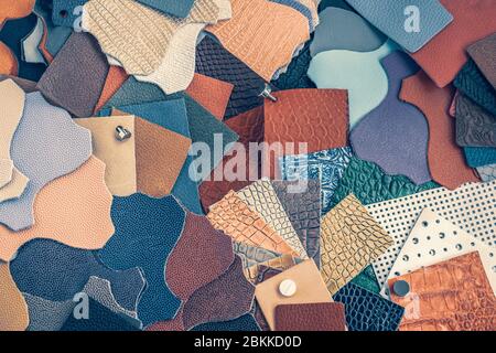 Varietà di campioni di pelle di diverse texture e colori, sfondo astratto, vista dall'alto, concetto di produzione Foto Stock