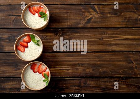 Tre tazze di carta artigianale con budino di tapioca con latte a base di piante Foto Stock