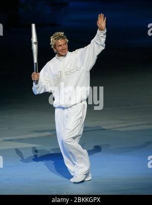 MANCHESTER - LUGLIO 25: Il giocatore di calcio britannico David Beckham che tiene la Jubilee Baton corre nello stadio del City of Manchester Stadium durante il 2002 Foto Stock