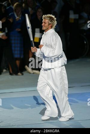 MANCHESTER - LUGLIO 25: Il giocatore di calcio britannico David Beckham che tiene la Jubilee Baton corre nello stadio del City of Manchester Stadium durante il 2002 Foto Stock