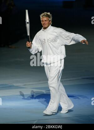 MANCHESTER - LUGLIO 25: Il giocatore di calcio britannico David Beckham che tiene la Jubilee Baton corre nello stadio del City of Manchester Stadium durante il 2002 Foto Stock