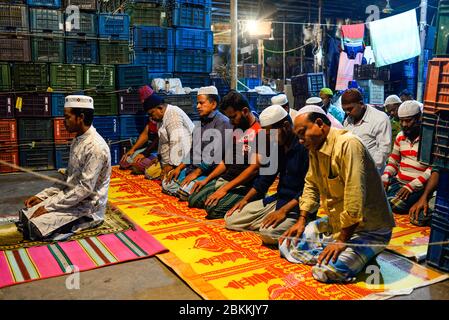 I lavoratori di un mercato all'ingrosso sono visti all'interno della moschea mentre pregano durante il mese santo di Ramadan. Ramadan è il mese olistico del calendario islamico in cui i devoti stanno digiunando dall'alba al tramonto. I musulmani di tutto il mondo celebrano il mese del Ramadan e hanno trovato vari modi per celebrare questo mese del Ramadan, poiché le restrizioni poste dai paesi per frenare la diffusione del Coronavirus hanno chiuso le moschee per impedire gli incontri. Foto Stock