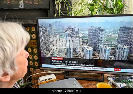 Una donna che guarda le notizie della BBC con lo sviluppo a Wuhan, Cina per quanto riguarda Covid-19 e il blocco. Foto Stock