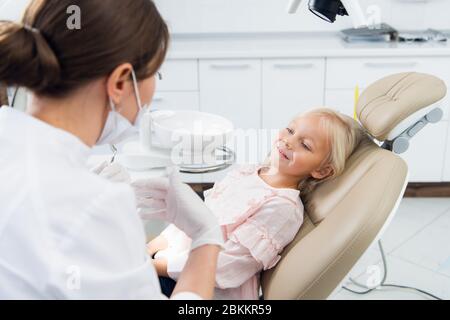 Primo piano di una bambina femminile che ha i suoi denti controllato da un medico non identificato. Foto Stock