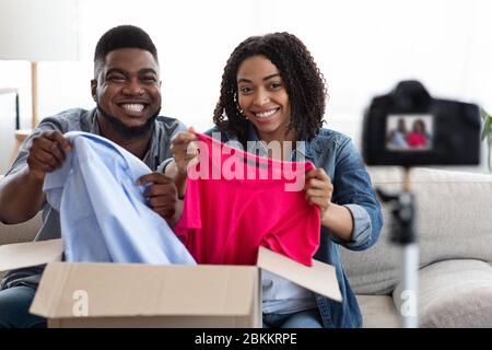 Disimballaggio Blog. Coppia African American Fashion Influencers registrazione di contenuti a casa Foto Stock