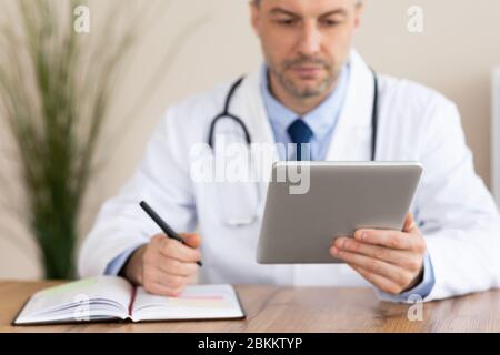 Primo piano del medico che compila la documentazione Foto Stock