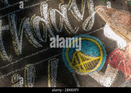 Una famiglia celebra il compleanno di una madre con un messaggio scritto in gesso in Piemonte, CA. Foto Stock