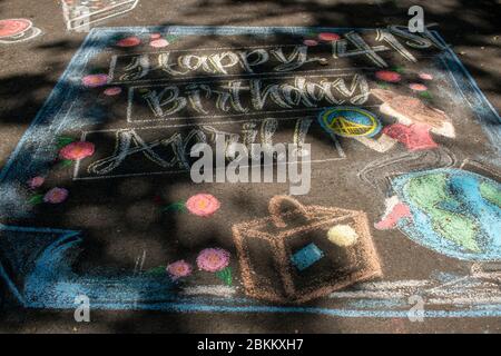 Una famiglia celebra il compleanno di una madre con un messaggio scritto in gesso in Piemonte, CA. Foto Stock