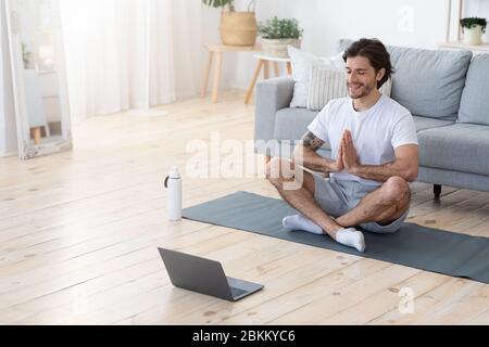Uomo attento e bello meditating da solo a casa Foto Stock