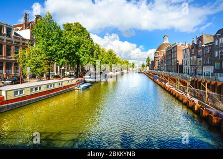 Le barche della casa sono ormeggiate lungo uno dei molti canali di Amsterdam in una giornata di sole all'inizio dell'autunno Foto Stock