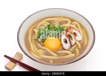 Le tagliatelle di Kare udon giapponesi in una ciotola con bacchette su sfondo bianco Foto Stock