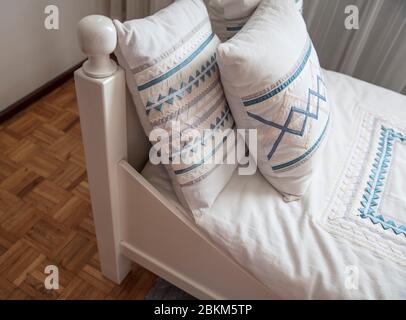 angolo letto singolo con cuscini bordati Foto Stock