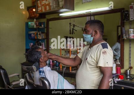 Un uomo che ottiene una rasatura durante il blocco del covid-19 in India Foto Stock