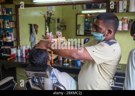 Un uomo che ottiene una rasatura durante il blocco del covid-19 in India Foto Stock