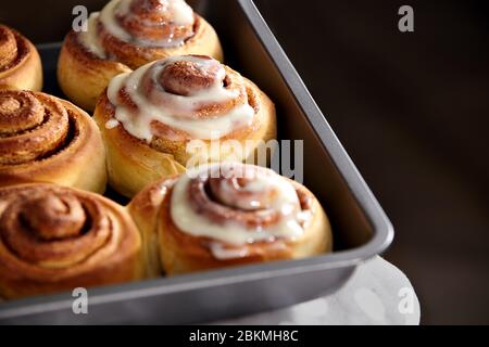 Forno fresco. I rotoli di cannella sono lubrificati. Primo piano cinnabon fatto in casa. Foto Stock