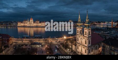 Budapest, Ungheria - veduta aerea della Chiesa parrocchiale di Sant'Anna in Piazza Batthyany al crepuscolo con l'edificio illuminato del Parlamento ungherese, Santo Stefano Foto Stock