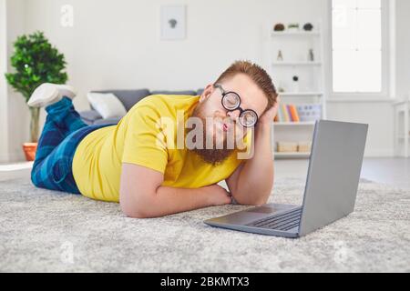 Online dating chat video chat call.Funny Fat uomo in occhiali di uno stolto con un laptop su una data online videochiamata chat applicazione in camera a casa. Foto Stock