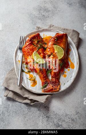 Cotta Red sea bass in kraft piastra bianca, concreto sfondo. Foto Stock