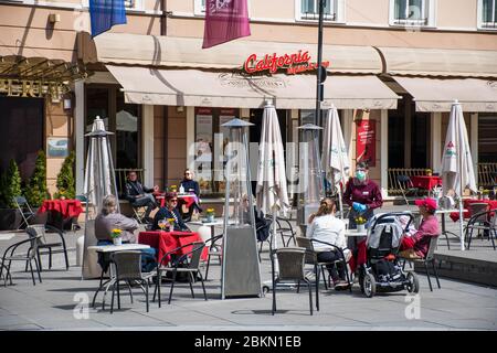 Bar e ristorante all'aperto con clienti e cameriere con maschera e guanto a Vilnius, capitale lituana che riapre nella vasta città di cafe all'aperto Foto Stock