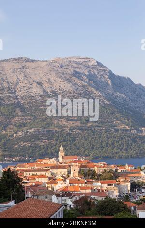 Isola di Korcula con la cattedrale, la città e le case in una giornata di sole durante il tramonto in estate. Bella architettura veneziana, alberi e montagna Foto Stock