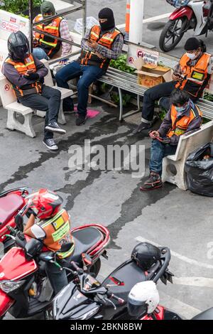 I tassisti di moto indossano maschera facciale in attesa dei clienti durante la pandemia Covid 19, Bangkok, Thailandia Foto Stock