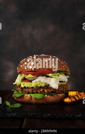 Delizioso hamburger di lenticchie vegane fatto in casa su uno sfondo rustico scuro Foto Stock