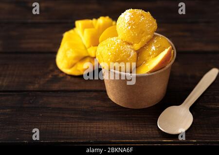 Vista dall'alto del rinfrescante sorbetto al mango vegano su sfondo grigio Foto Stock
