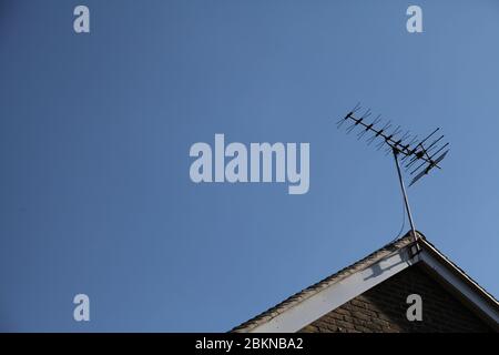 Antenna TV in metallo di vecchio stile montata sul tetto a tetto del Regno Unito contro cielo blu giorno Foto Stock