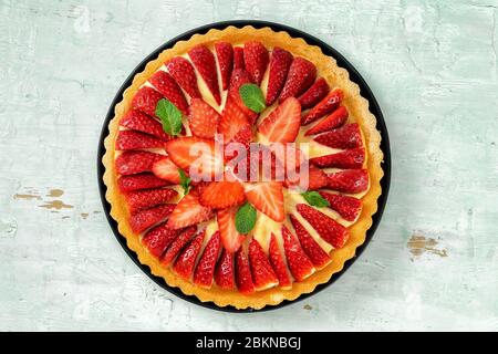 Vista dall'alto della torta di fragole su sfondo di menta chiara Foto Stock