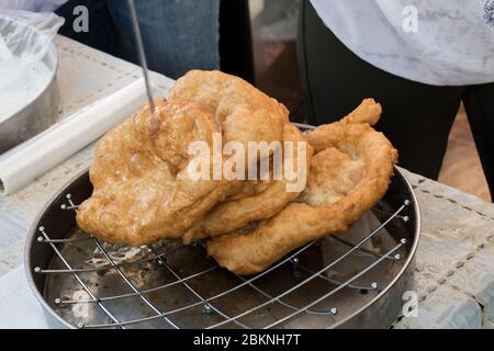 Chef che prepara churros fritti o ciambelle e pancake durante il brunch a buffet in giardino. Cibo buffet Brunch Catering Dining Party Sharing Conciep Foto Stock