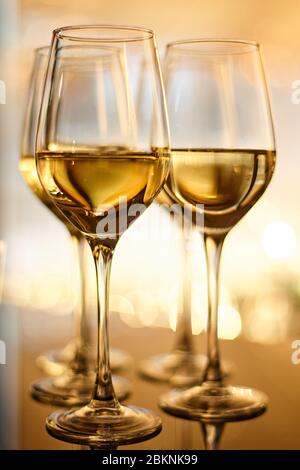 Diversi bicchieri di vino bianco su una superficie riflettente Foto Stock