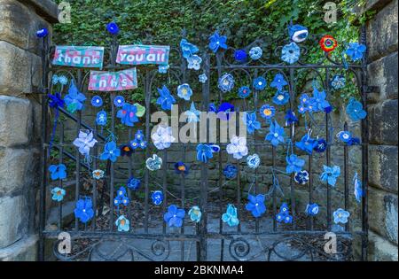 Una porta della chiesa a Baaildon, Yorkshire decorata con fiori a maglia blu a sostegno del NHS durante la Pandemia di Coronavirus. Foto Stock