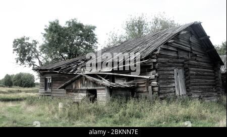 Vecchia casa in legno nella regione di Arkhangelsk, una casa residenziale villaggio in un villaggio forestale, persone abbandonate e a bordo casa. Russia Foto Stock