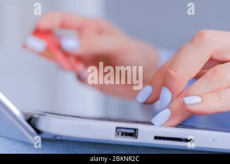 Donna che utilizza la tastiera del computer portatile, che detiene la carta di credito, che acquista prodotti o che ordina online - primo piano vista laterale. Shopping online, e-commerce, vendita Foto Stock