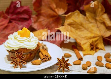 Cupcake di zucca dolce con cannella e noci su sfondo colorato autunno foglie. Dessert autunnale. Foto Stock