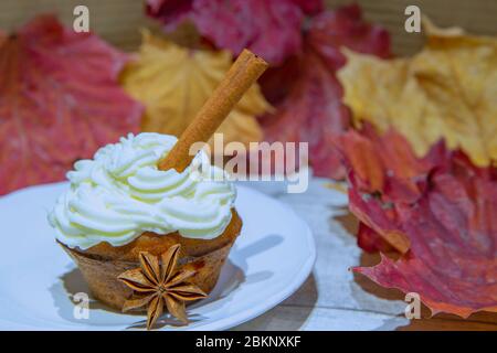 Muffin di zucca dolci con cannella e noci su sfondo colorato foglie autunnali. Dessert autunnale. Foto Stock