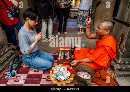 Un monaco buddista che dà una benedizione, Angkor Wat, Siem Reap, Siem Reap Province, Cambogia. Foto Stock