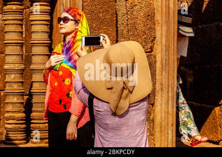 I visitatori che hanno scattato fotografie al tempio di Banteay Srey, al complesso del tempio di Angkor Wat, a Siem Reap, Cambogia. Foto Stock